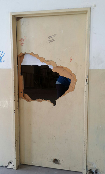 Una de las puertas destruidas de un aula.