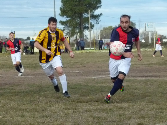 Damián López (Sarmiento) y Alejandro Aranda (Estrada) van a disputar el balón.