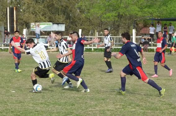 César Guidi intenta avanzar con el balón ante la marca de Fernández de Náutico.